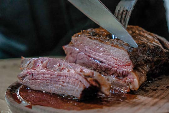 Argentine beef being carved at La Faustina